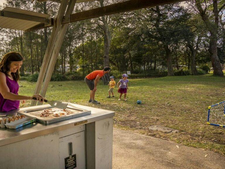Family enjoying a barbecue lunch and a casual game of soccer. Photo: John Spencer/OEH
