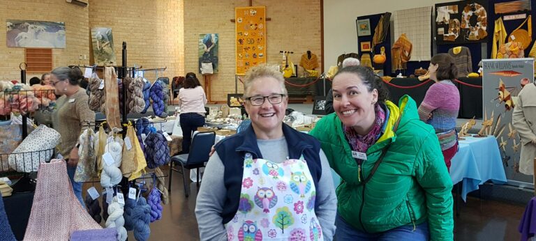 2 of our happy helpers with a background of a previous winter wool fair