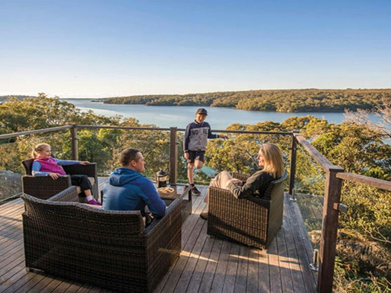 A family enjoying the view from the balcony of Hilltop Cottage in Royal National Park. Photo: John