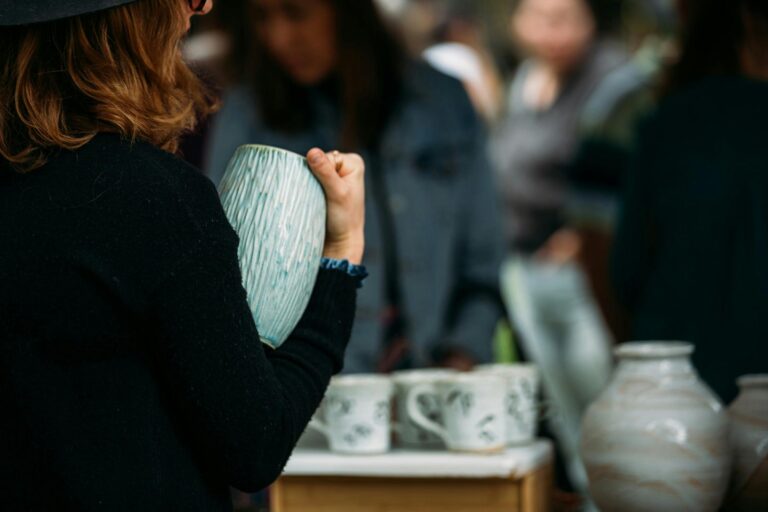 Woman holding ceramic vase.