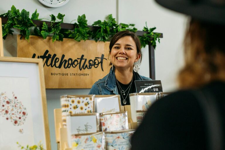 Stallholder smiling at camera from their indoor stall.