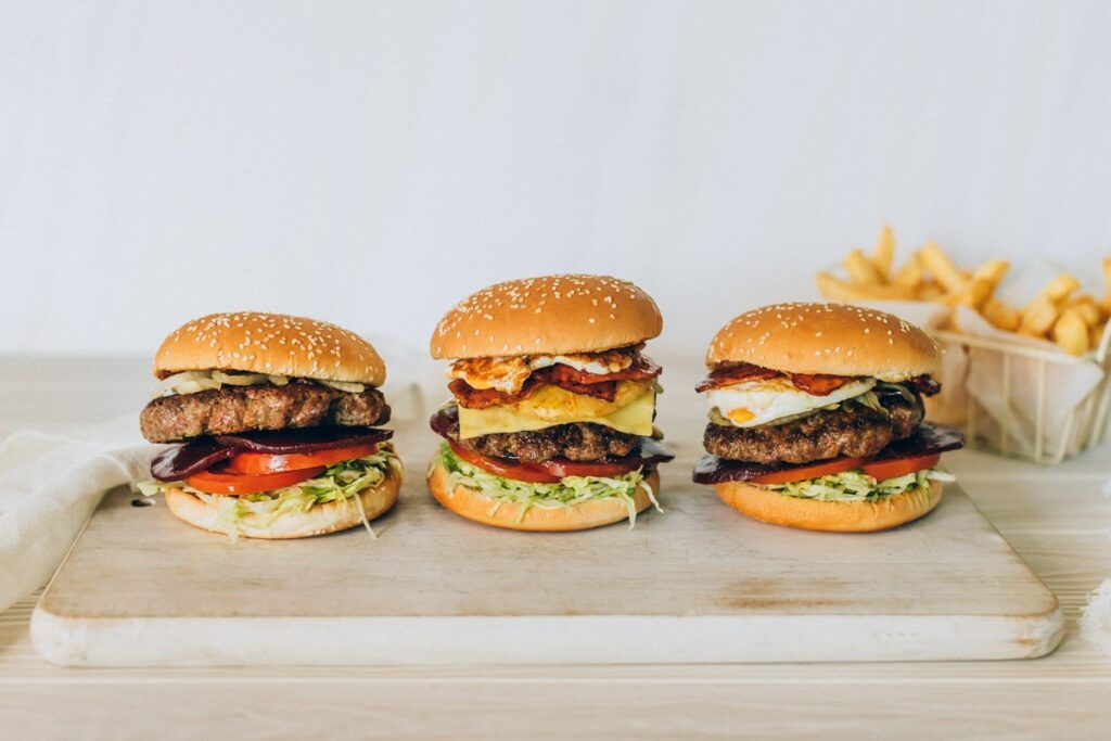 Three hamburgers in a row on a marble board 