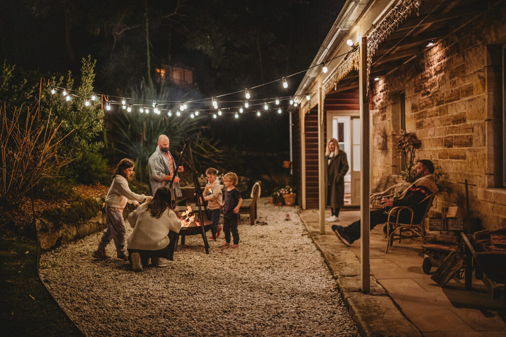 Families around a fire outside of Simpson Cottage