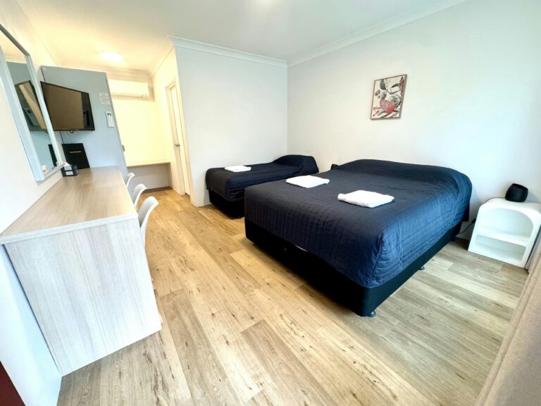 Sutherland Motel Twin or Triple Room, queen plus single bed, bedside tables, lamp, television, desk