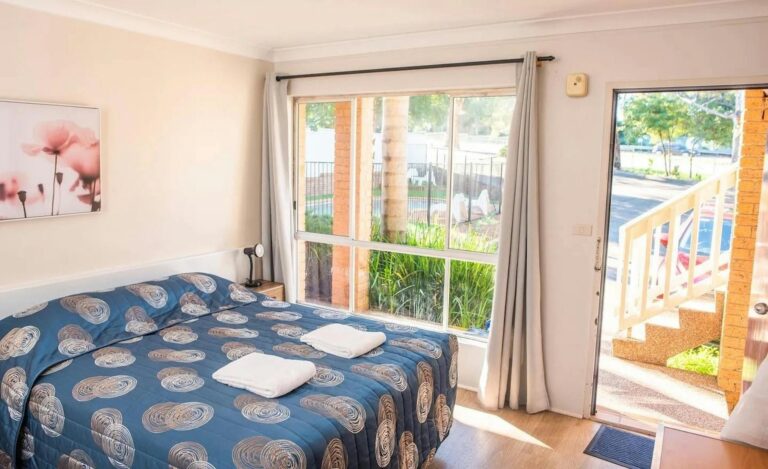 Ground floor queen room with view of swimming pool and parking area at Sutherland Motel