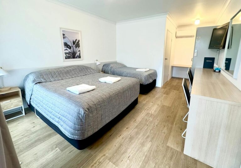 Sutherland Motel with one queen bed and one single bed, bedside tables, television, long work desk
