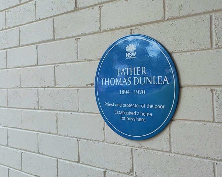 Blue Plaque on white painted brick wall